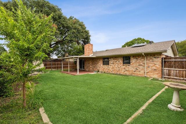 rear view of house with a patio area and a lawn