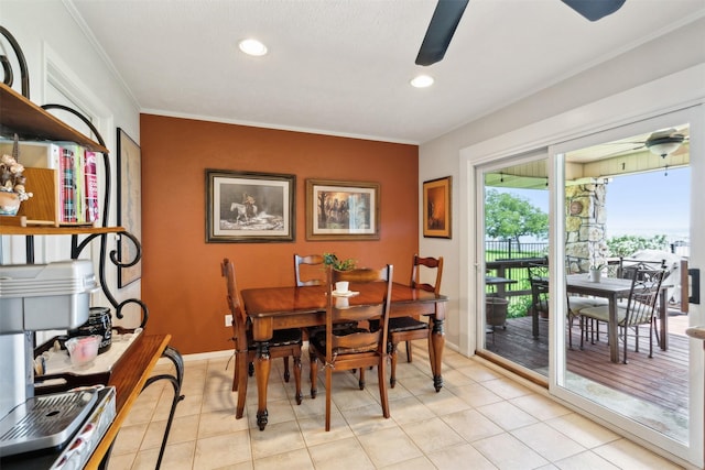 tiled dining space with ceiling fan and crown molding