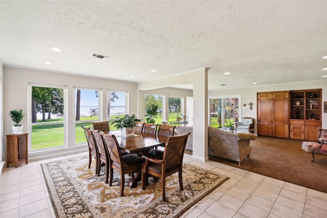 tiled dining room with a textured ceiling