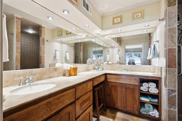 bathroom featuring a tile shower, vanity, and ornamental molding