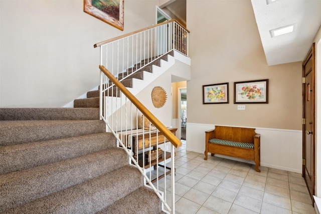 stairs with tile patterned flooring and a skylight