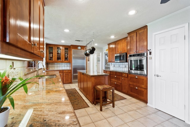 kitchen featuring a kitchen island, sink, stainless steel appliances, and tasteful backsplash