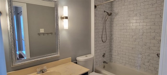 full bathroom featuring tiled shower / bath combo, vanity, and toilet