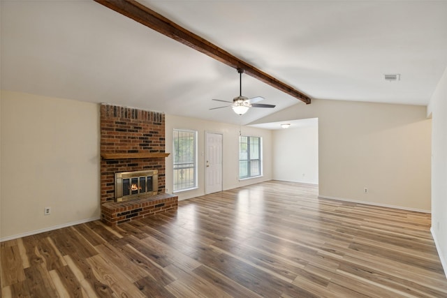 unfurnished living room featuring hardwood / wood-style floors, vaulted ceiling with beams, a brick fireplace, and ceiling fan