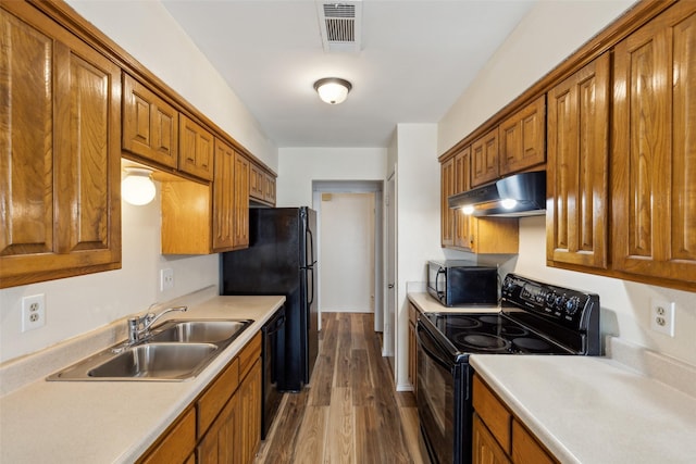 kitchen with dark hardwood / wood-style flooring, sink, and black appliances