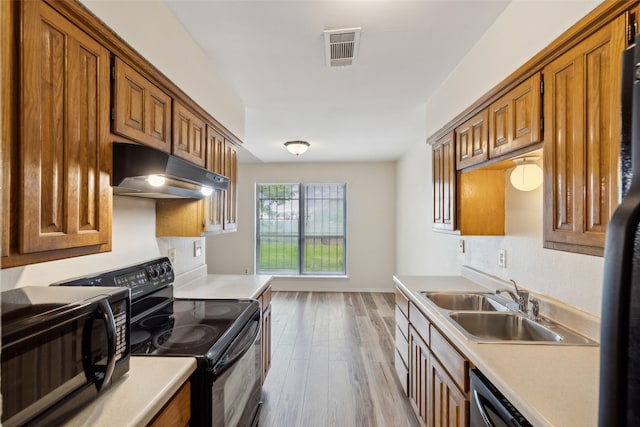 kitchen with sink, light hardwood / wood-style flooring, and black appliances