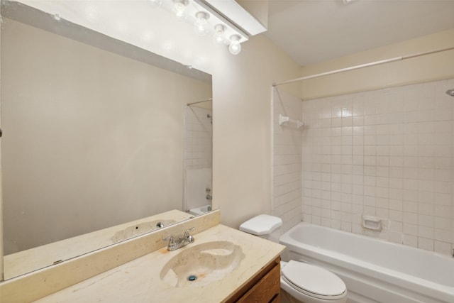 full bathroom featuring vanity, tiled shower / bath combo, and toilet