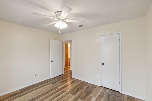 unfurnished bedroom featuring ceiling fan, a closet, and hardwood / wood-style flooring