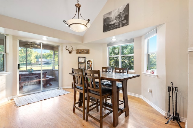 dining area featuring high vaulted ceiling, a wealth of natural light, and light hardwood / wood-style flooring