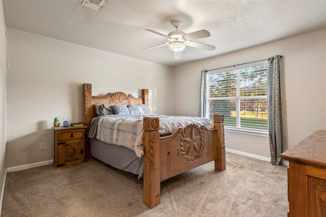 bedroom with light carpet, a textured ceiling, and ceiling fan