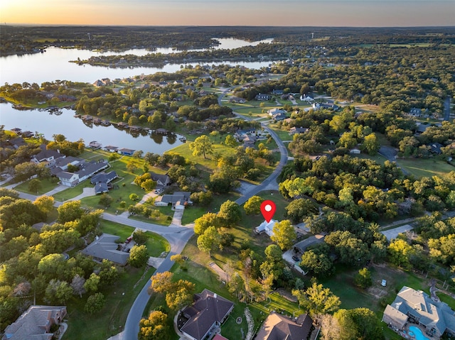 aerial view at dusk featuring a water view