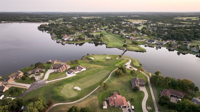 aerial view at dusk featuring a water view