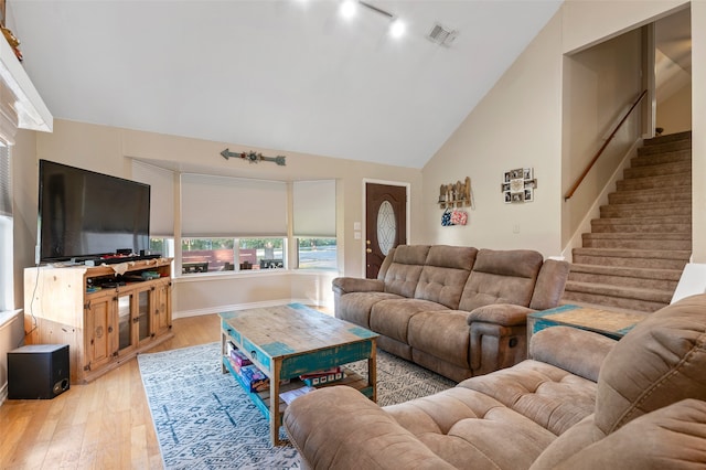 living room featuring light hardwood / wood-style floors, high vaulted ceiling, and track lighting