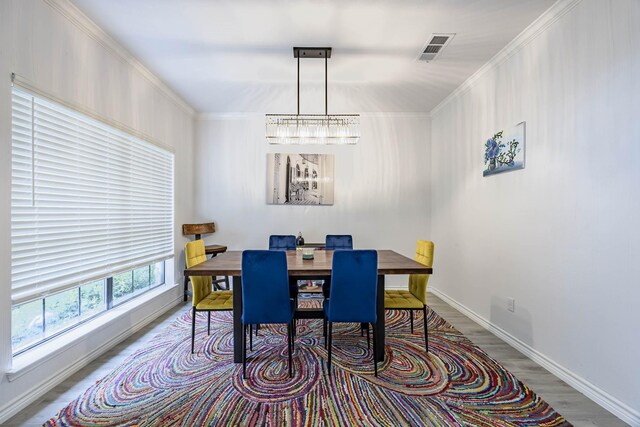 dining room featuring wood-type flooring and crown molding