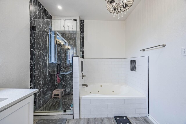 bathroom with vanity, hardwood / wood-style flooring, a chandelier, and plus walk in shower