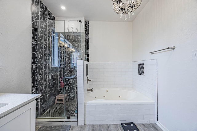 full bath featuring a shower stall, a tub with jets, wood finish floors, and vanity