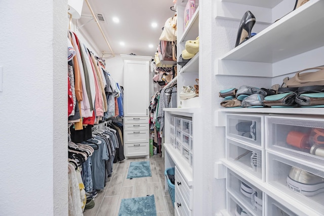 spacious closet featuring wood finish floors and visible vents