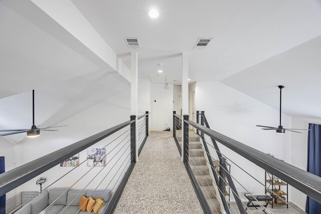 hallway with lofted ceiling, attic access, visible vents, and an upstairs landing