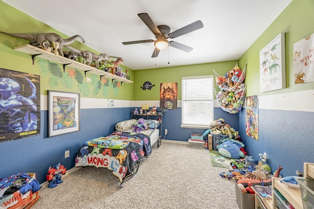 bedroom with carpet floors, a textured wall, baseboards, and a ceiling fan