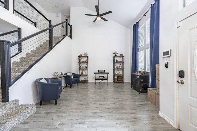 interior space featuring light hardwood / wood-style flooring, ceiling fan, and high vaulted ceiling