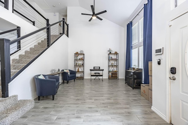 foyer with high vaulted ceiling, wood tiled floor, stairway, and a ceiling fan