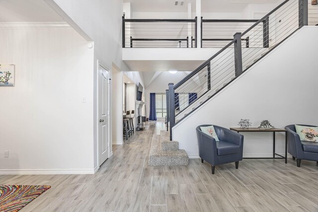 entrance foyer with light wood-type flooring and a towering ceiling