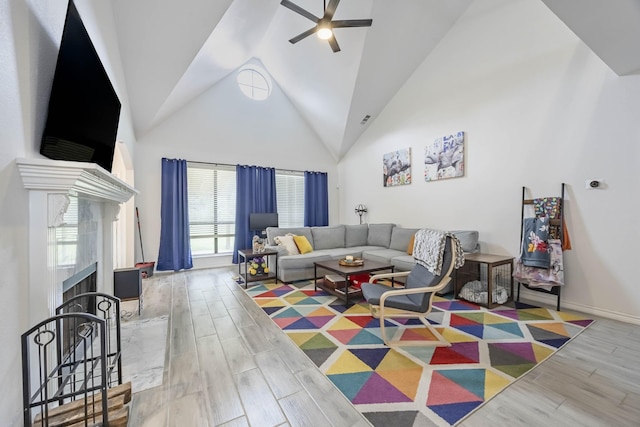 living room featuring visible vents, a high end fireplace, ceiling fan, wood finished floors, and high vaulted ceiling