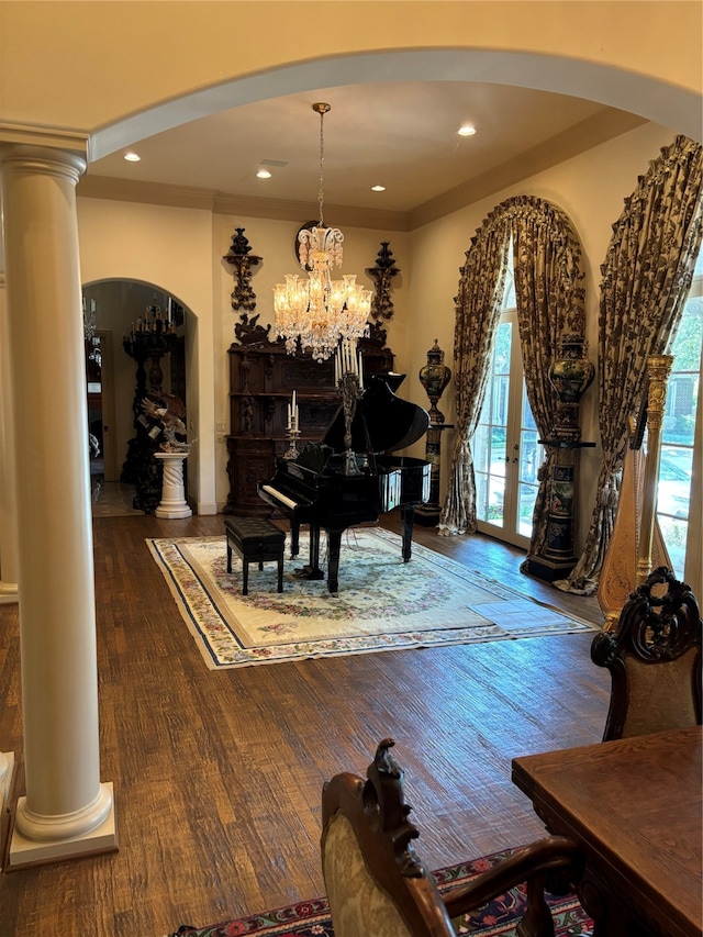 misc room with ornate columns, crown molding, dark hardwood / wood-style flooring, and a chandelier