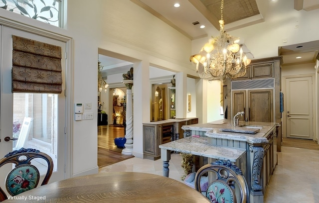 dining room featuring a chandelier, a high ceiling, light wood-type flooring, and crown molding