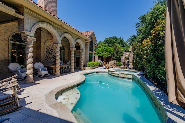 view of pool with an in ground hot tub and a patio