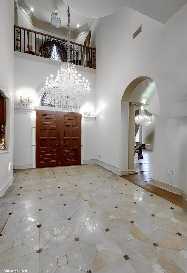 entrance foyer featuring a notable chandelier, a healthy amount of sunlight, and a towering ceiling