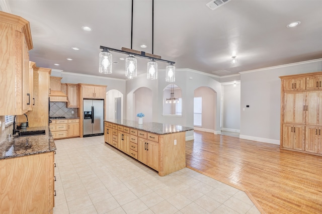 kitchen featuring pendant lighting, ornamental molding, light hardwood / wood-style flooring, light brown cabinetry, and stainless steel refrigerator with ice dispenser