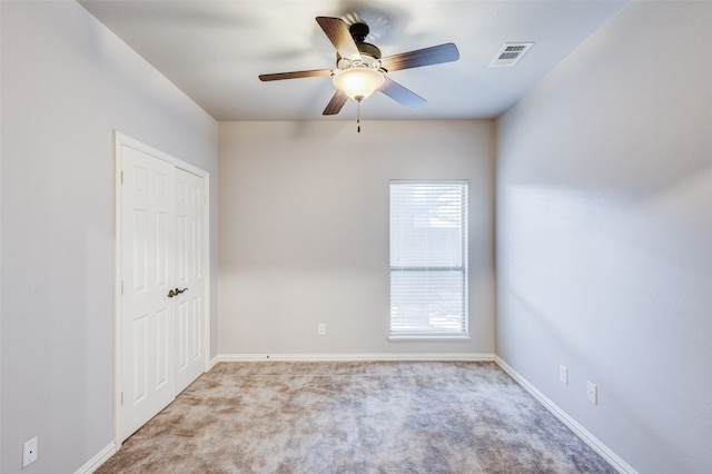 carpeted spare room featuring ceiling fan