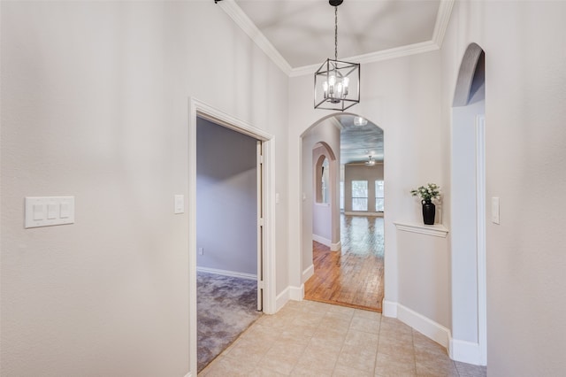 foyer featuring light wood-type flooring, an inviting chandelier, and crown molding