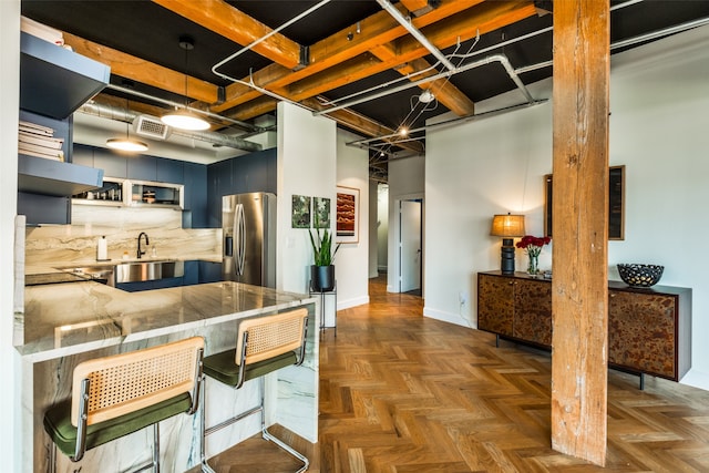 kitchen featuring stainless steel refrigerator with ice dispenser, dark parquet flooring, kitchen peninsula, and a breakfast bar