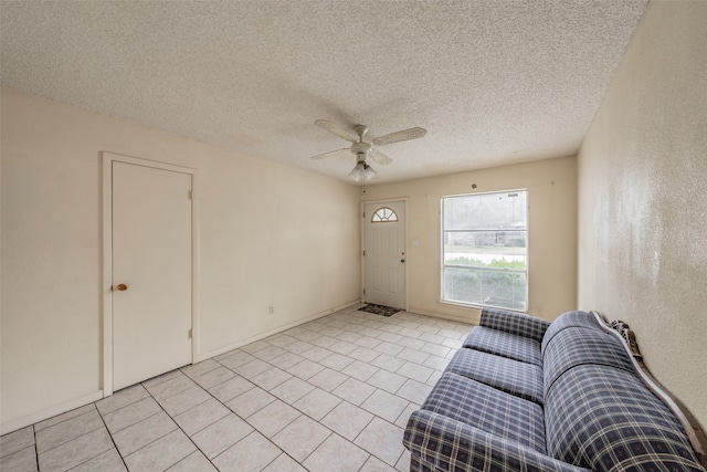 unfurnished living room featuring a textured ceiling, light tile patterned floors, and ceiling fan