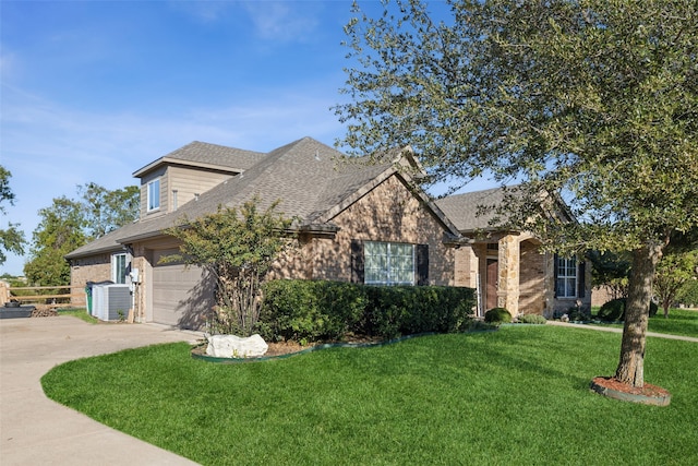 view of front of home featuring a garage, a front yard, and central AC