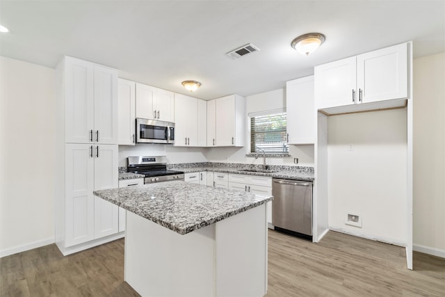 kitchen with a center island, white cabinets, and appliances with stainless steel finishes