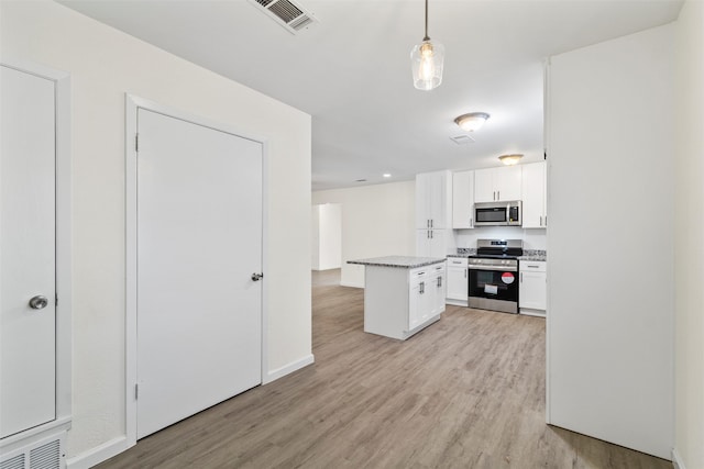 kitchen featuring pendant lighting, light hardwood / wood-style flooring, appliances with stainless steel finishes, white cabinets, and a kitchen island