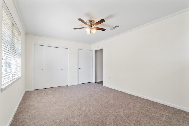 unfurnished bedroom featuring ceiling fan, ornamental molding, and carpet