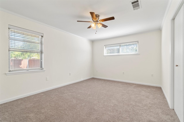 spare room with crown molding, light colored carpet, and ceiling fan