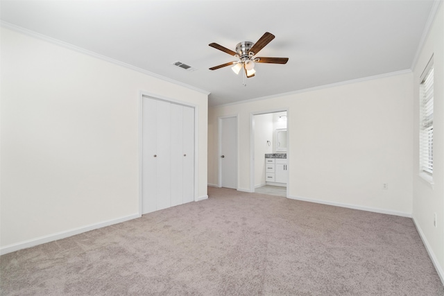 unfurnished bedroom with light carpet, crown molding, ensuite bath, and ceiling fan