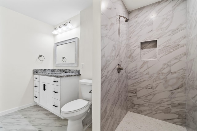 bathroom featuring vanity, a tile shower, and toilet