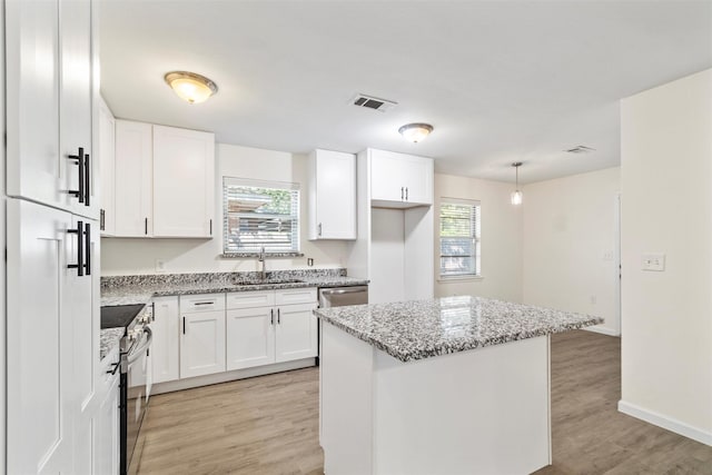 kitchen featuring a kitchen island, sink, white cabinets, and light hardwood / wood-style flooring