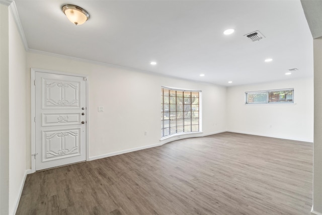 unfurnished room with ornamental molding and hardwood / wood-style floors