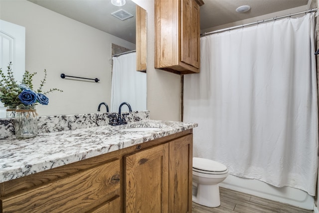 full bathroom with shower / bath combo with shower curtain, hardwood / wood-style floors, toilet, and vanity