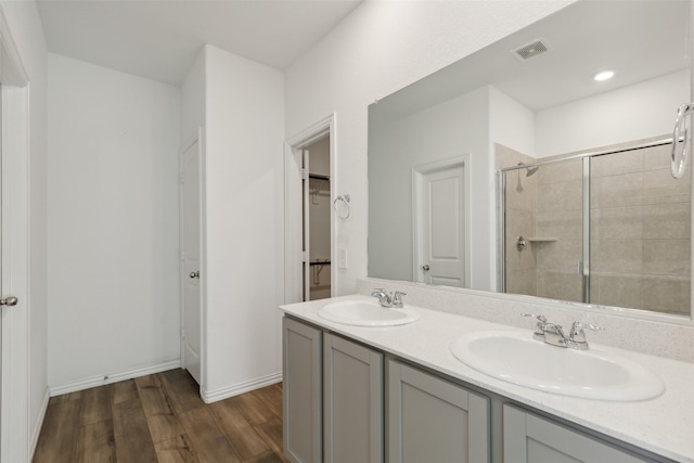 bathroom with vanity, wood-type flooring, and a shower with door