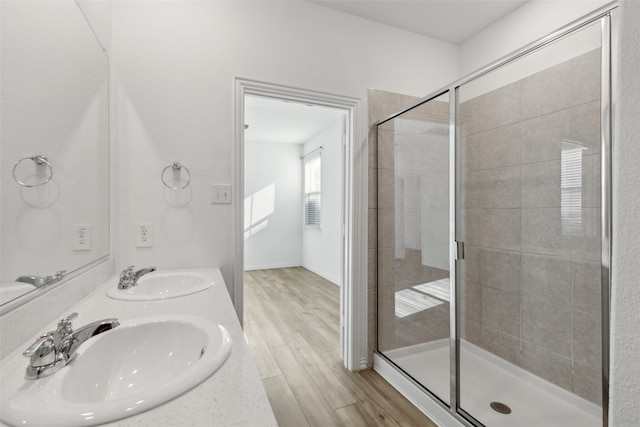 bathroom with hardwood / wood-style floors, walk in shower, and vanity