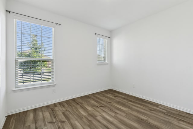 unfurnished room with dark wood-type flooring and plenty of natural light