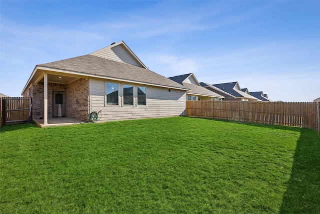 rear view of house with a yard and a patio